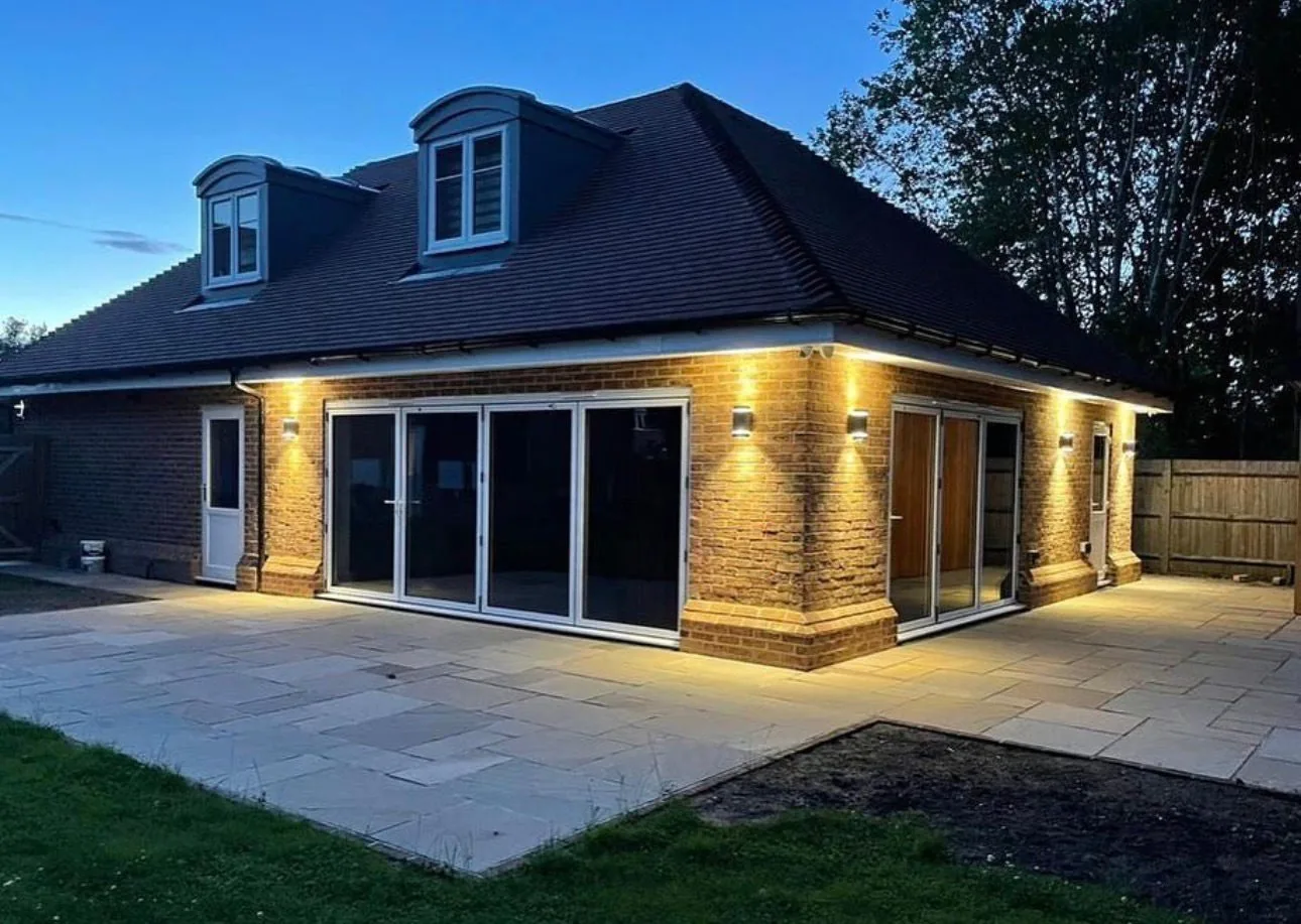 Brick bungalow with bi-fold doors and exterior uplighting installed by Cruise Electrical